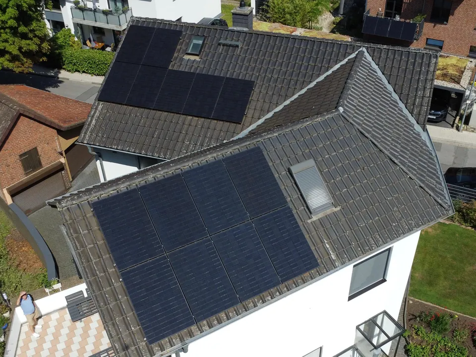 Wohnhaus mit Solarmodulen auf Haupt- und Anbaudach, Luftaufnahme